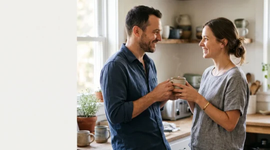 Un couple partageant un moment matinal complice ou l'un des partenaires tient une promesse simple du quotidien