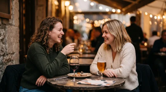 Deux personnes partageant un moment de complicité et de rire lors d'une premiere rencontre, comme si elles se connaissaient depuis toujours
