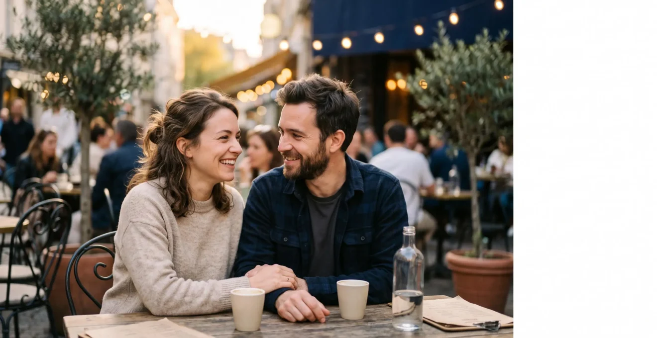 Un couple assis face à face sur une terrasse, échangeant un regard complice et apaisé au coucher du soleil